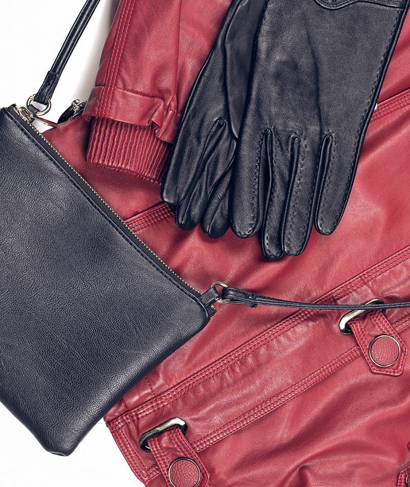 Guantes y bolso negro de cuero junto a una cazadora roja también de cuero.